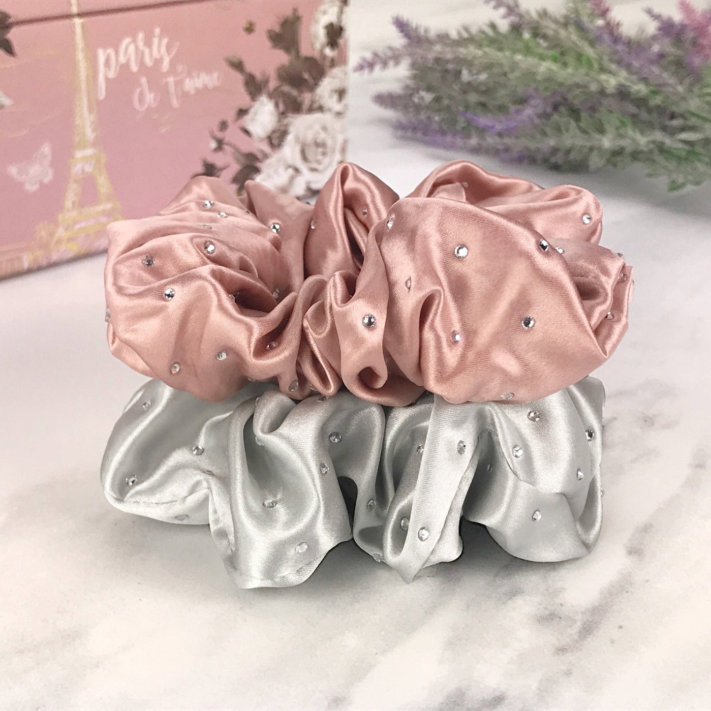 Celestial Silk scrunchies with crystals, silk hair ties with rhinestones pink and silver silk hair scrunchies stacked on marble vanity with lavender and pink jewelry box
