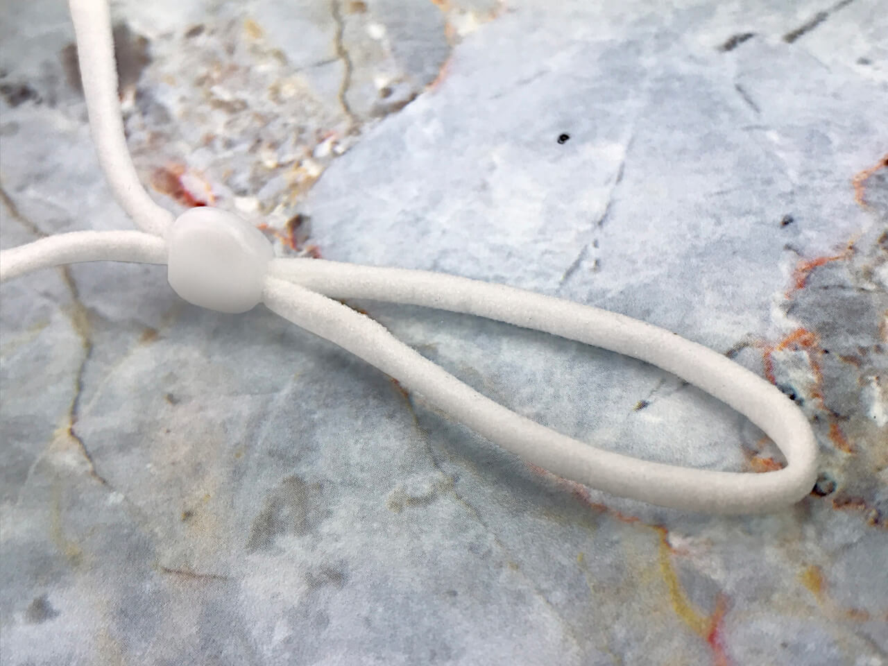 gold pleated silk face mask pleated gold silk face mask gold silk face covering close up of adjustable ear strap