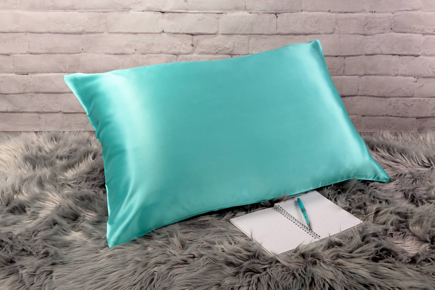 Celestial Silk Aqua 25 momme Silk Pillowcase on rug with notebook and pretty pen