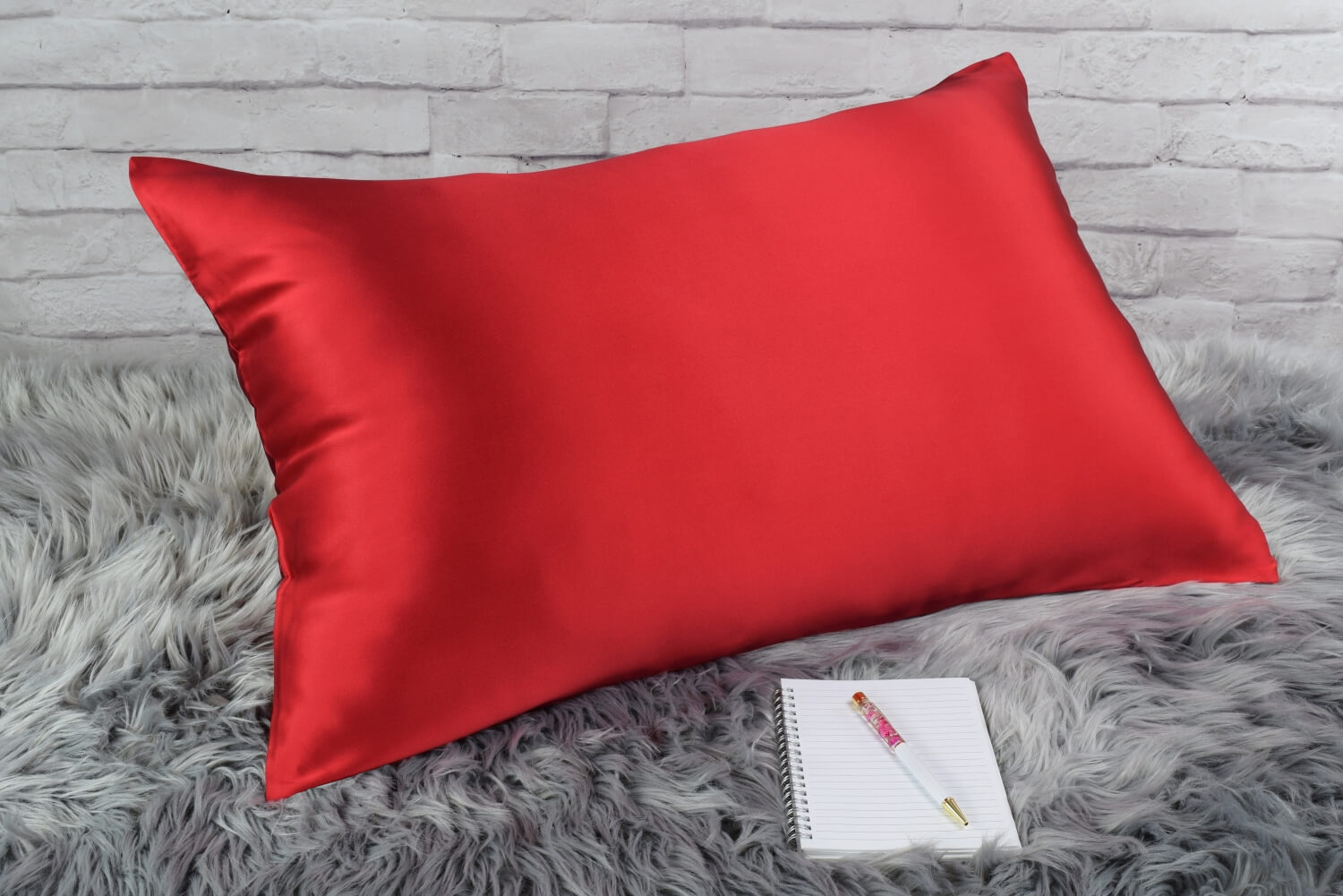 Celestial Silk Bright Red 25 momme Silk Pillowcase on rug with notebook and pretty pen