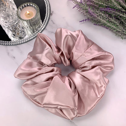 oversized vintage pink silk scrunchie on marble counter with candle