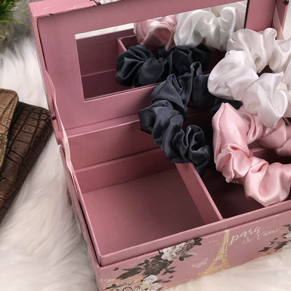 Celestial Silk large charcoal ivory and pink silk scrunchies stacked on marble counter with plant and wallet in the background