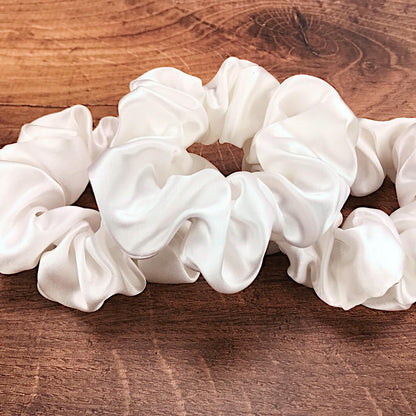  Large undyed ivory silk hair ties by Celestial Silk laying in a pile on a wood vanity