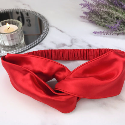 celestial silk twisted red silk headband for hair on counter with lavender and candle