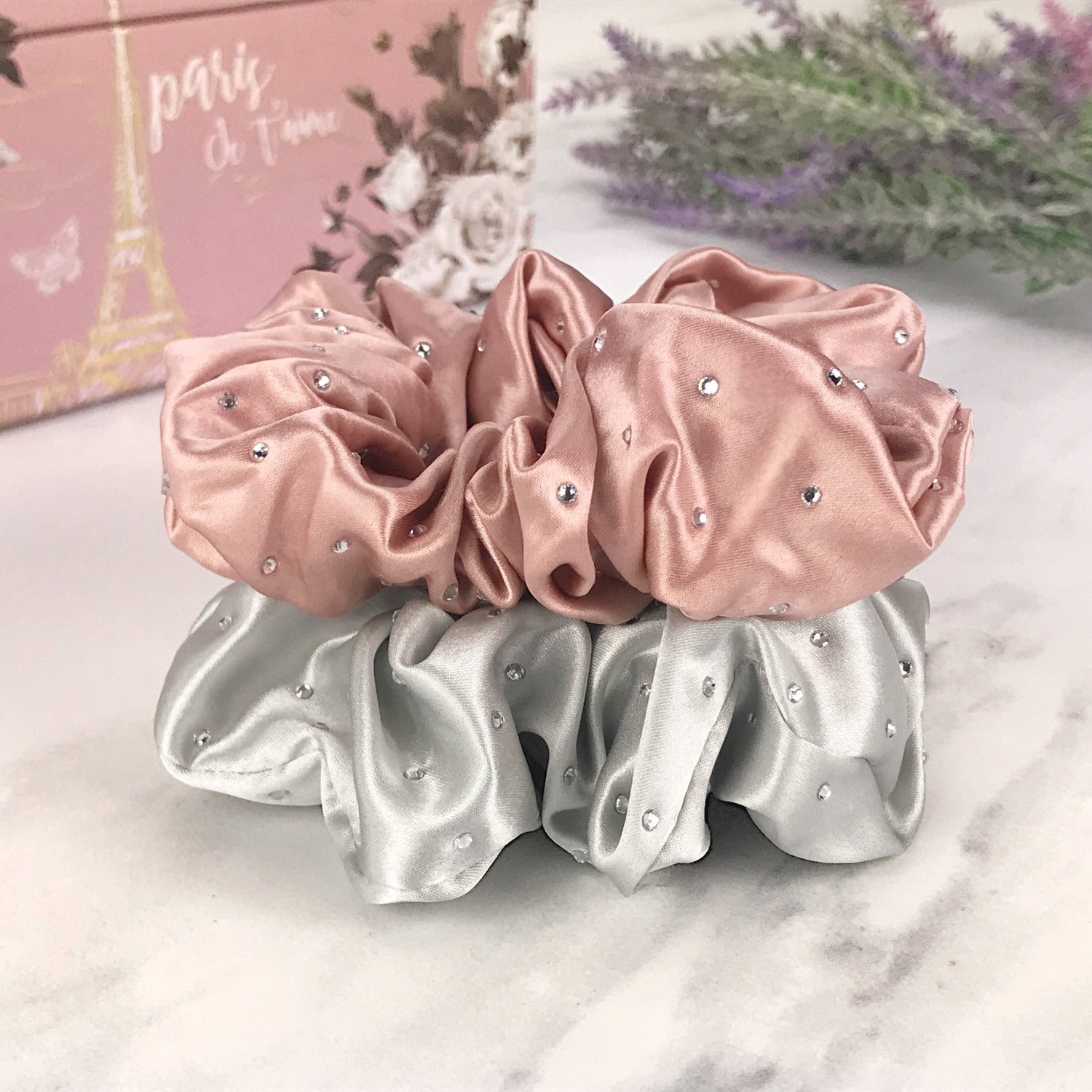 Celestial Silk scrunchies with crystals, silk hair ties with rhinestones pink and silver silk hair scrunchies stacked on marble vanity with lavender and  pink jewelry box