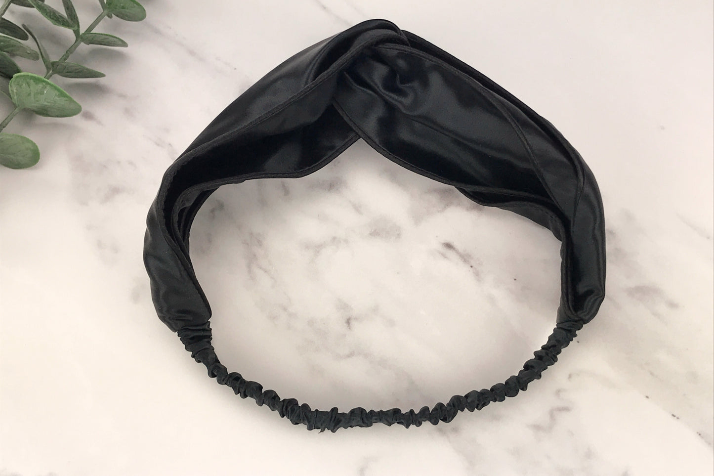 celestial silk twisted black silk headband for hair on counter with aloe