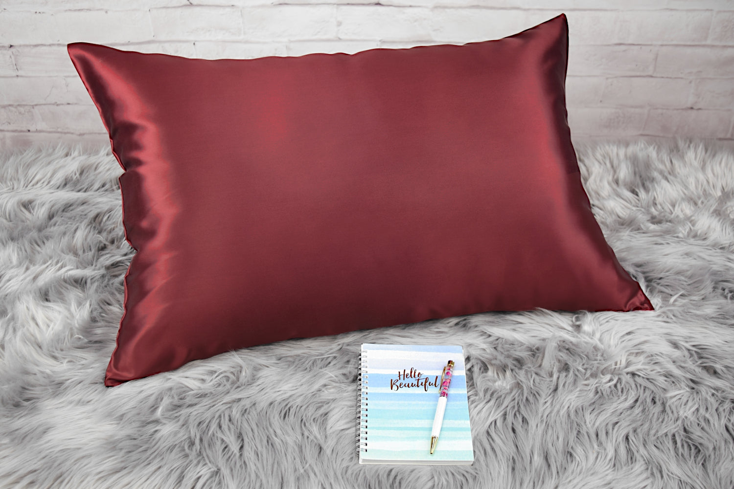 Celestial Silk Maroon 25 momme Silk Pillowcase on rug with notebook and pretty pen