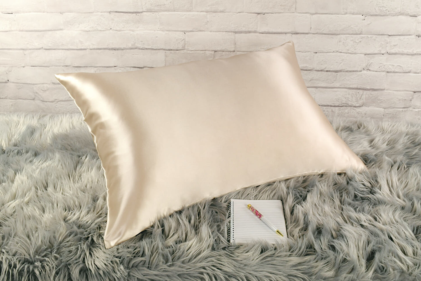 Celestial Silk Taupe 25 momme Silk Pillowcase on rug with notebook and pretty pen