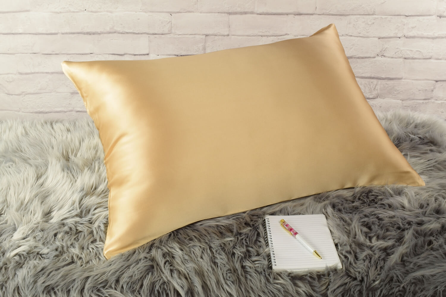 Celestial Silk 25 momme gold silk pillowcase on faux fur rug with notebook and pretty pen