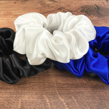 blue white black silk scrunchies mulberry silk scrunchies for hair laying on wood vanity