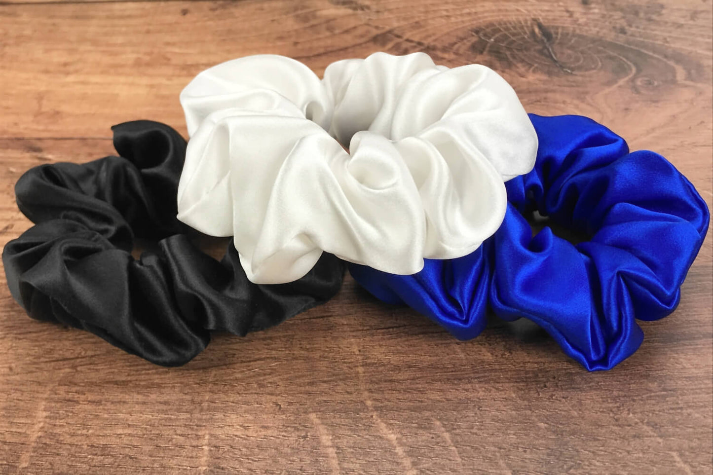 blue white black silk scrunchies mulberry silk scrunchies for hair laying on wood vanity