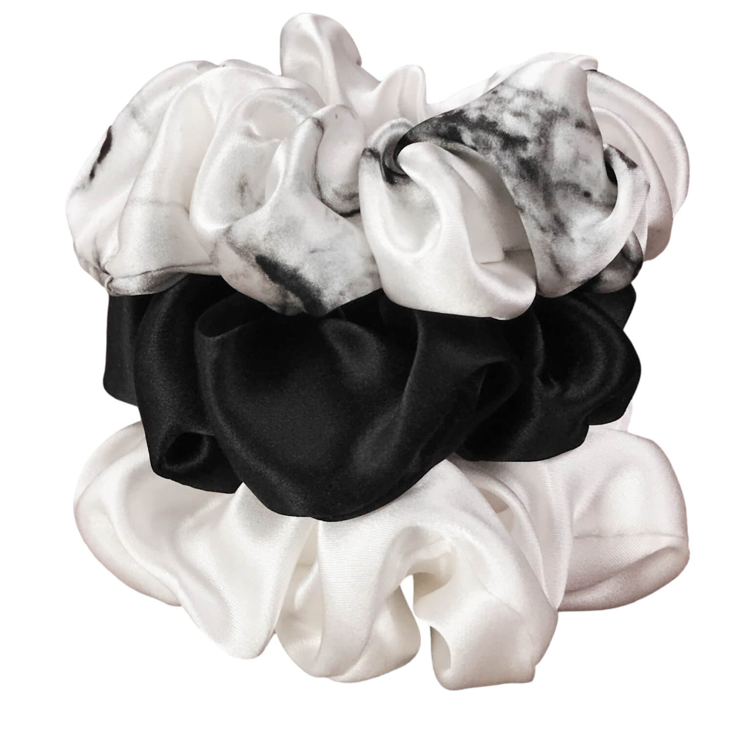 White marble, ivory and black silk scrunchies by celestial silk stacked with a white background