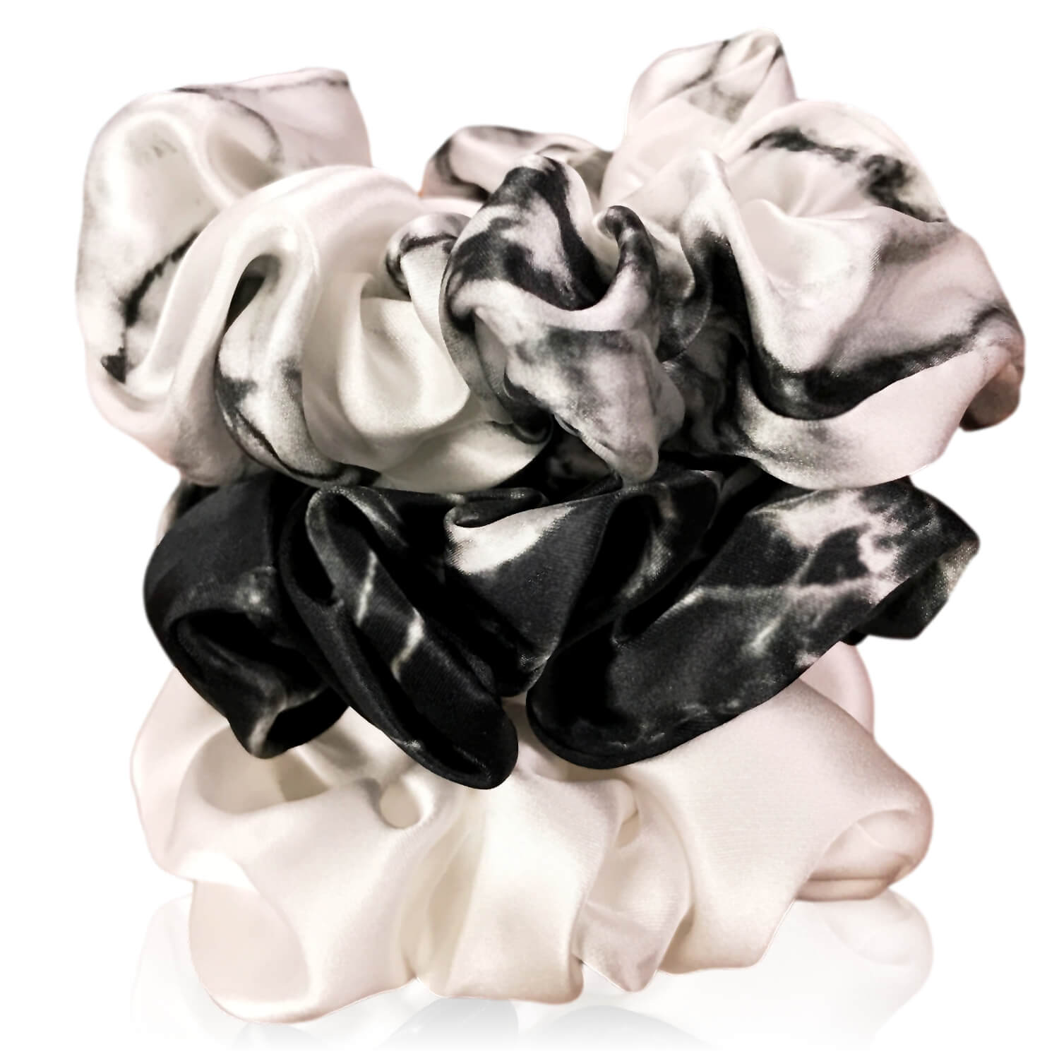 White marble, ivory and black marble silk scrunchies by celestial silk stacked with a white background