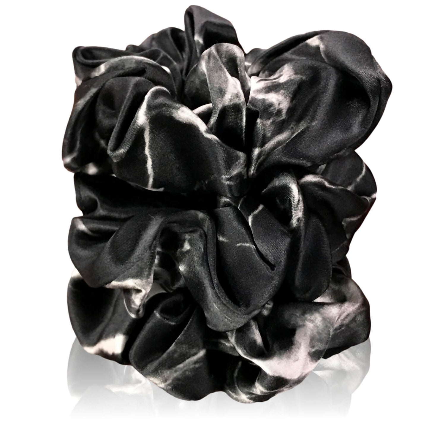 Black marble silk scrunchies by celestial silk stacked with a white background