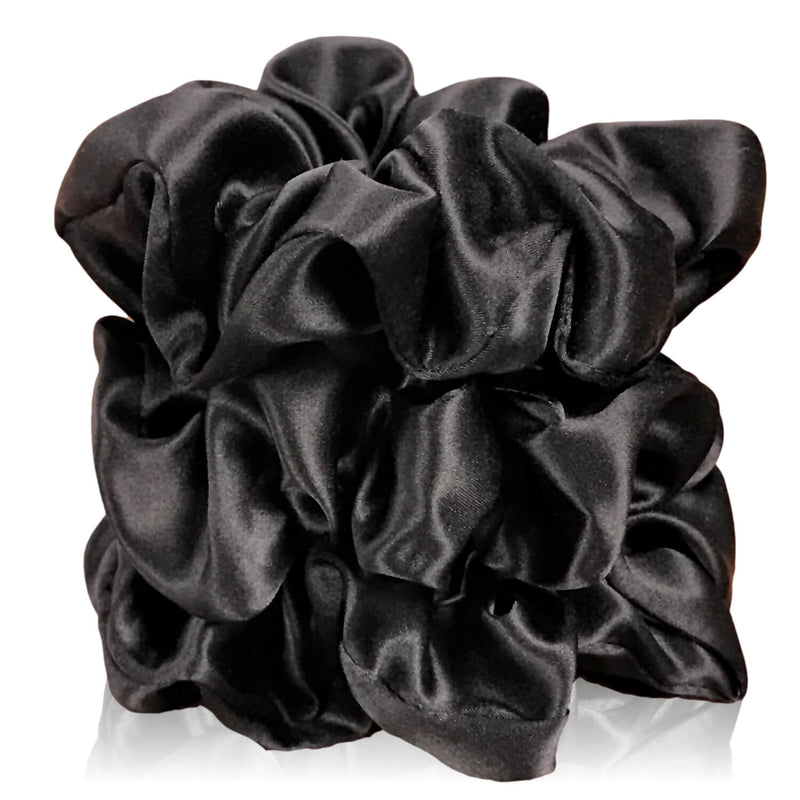 Black silk scrunchies by celestial silk stacked with a white background