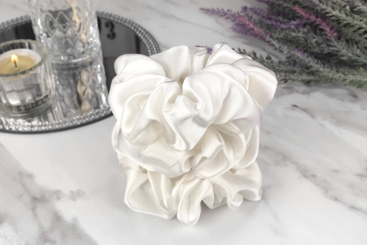  Celestial Silk large undyed ivory silk scrunchies stacked on marble counter with lavender plant and a candle in the background