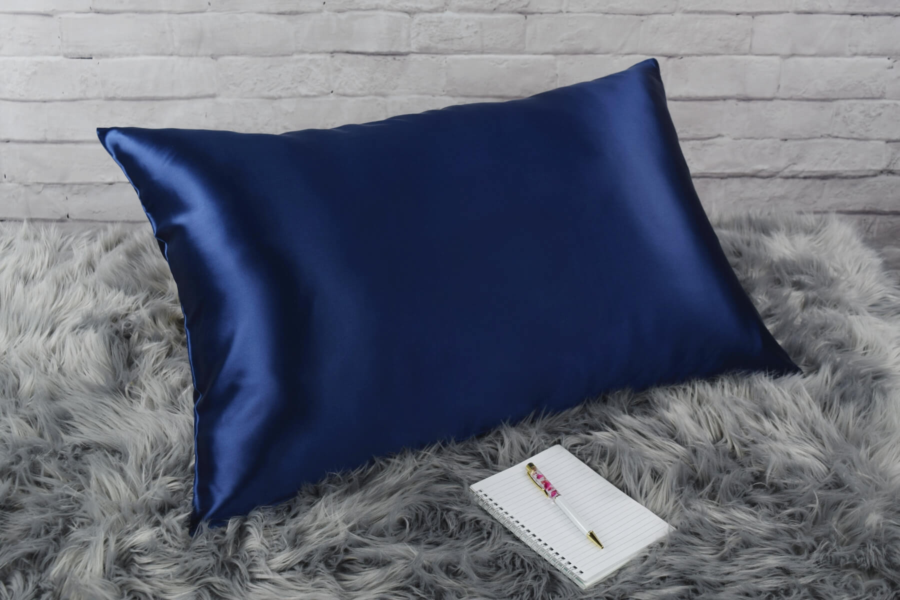 Celestial Silk 25 momme navy blue silk pillowcase on faux fur rug with notebook and pretty pen