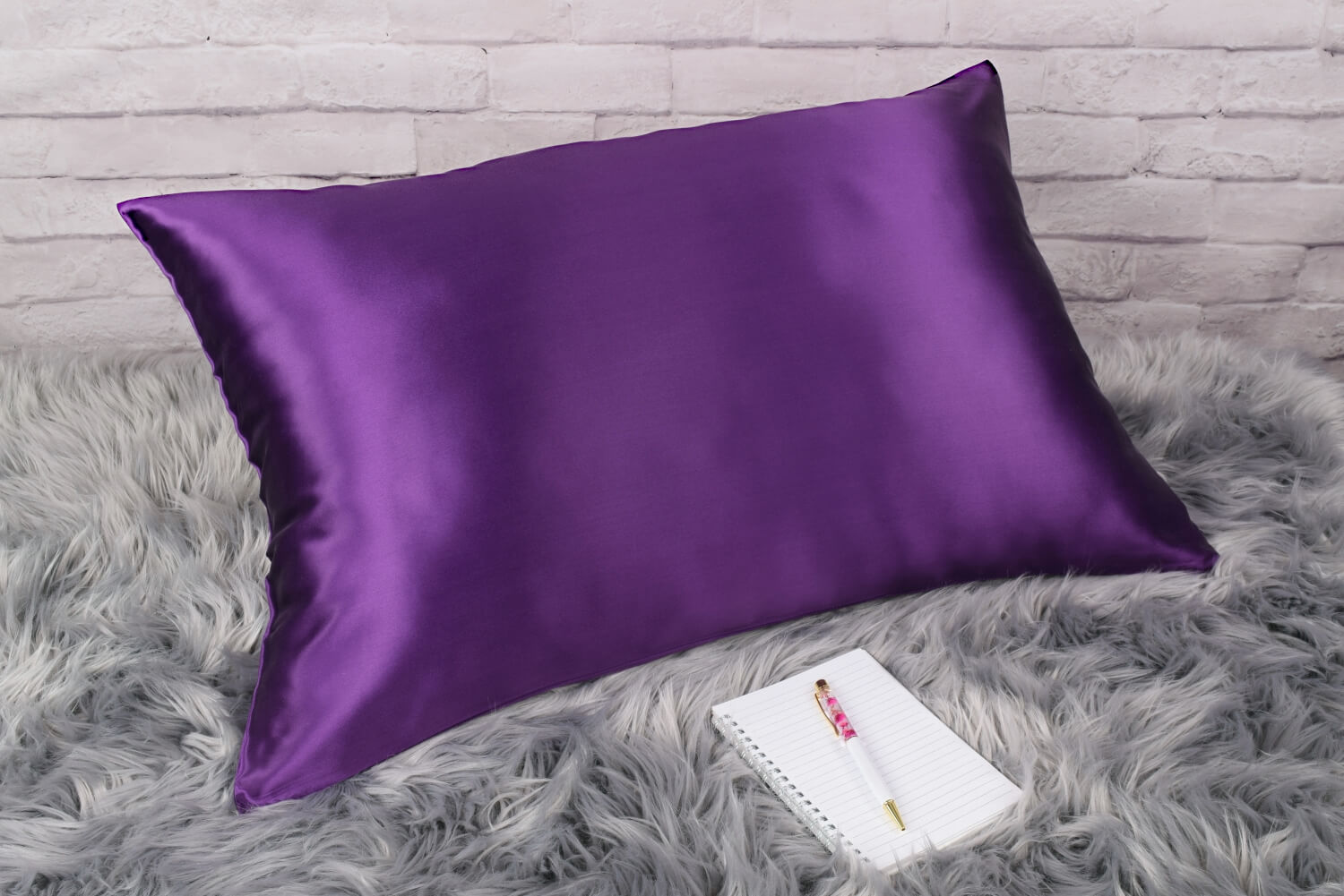 Celestial Silk 25 momme plum silk pillowcase on faux fur rug with notebook and pretty pen