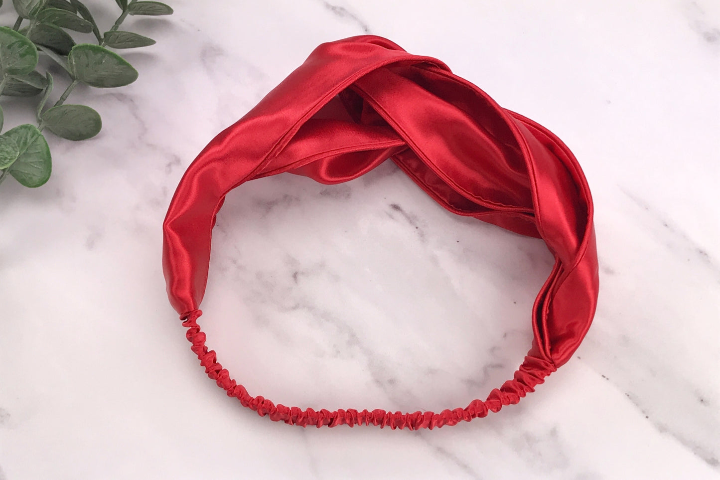celestial silk twisted red silk headband for hair on counter with aloe