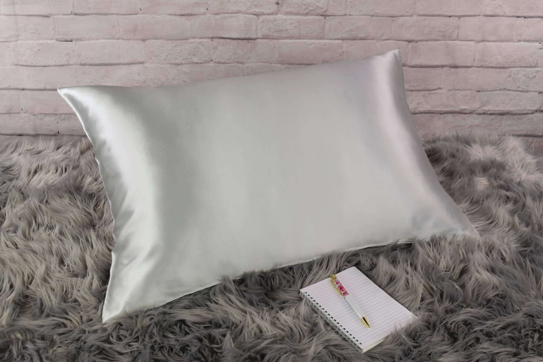 Celestial Silk 25 momme silver silk pillowcase on faux fur rug with notebook and pretty pen