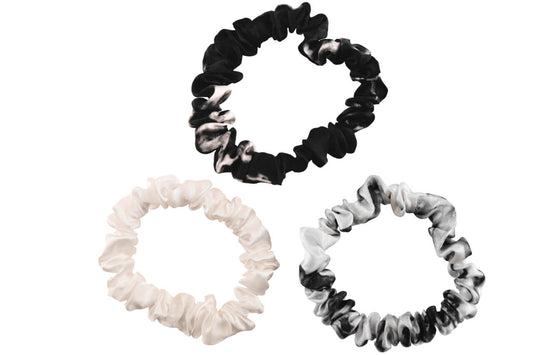 White marble ivory black marble silk scrunchies by celestial silk stacked with a white background