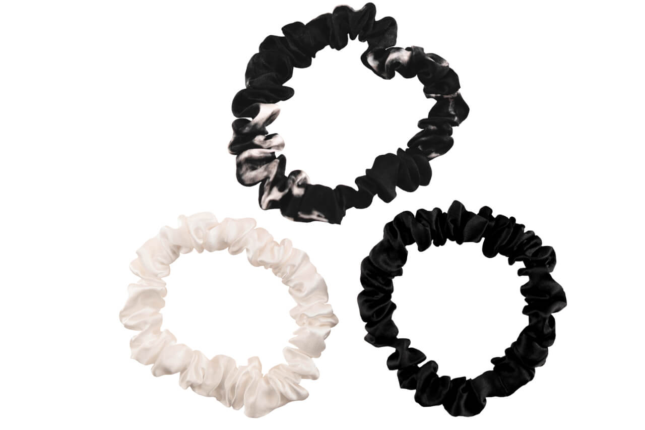 Black marble black and ivory silk scrunchies by celestial silk stacked with a white background