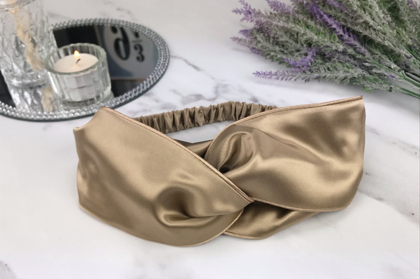 celestial silk twisted taupe silk headband for hair  on counter with lavender and mirror tray